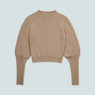 Beige cropped sweater with puffed sleeves on a light blue background.